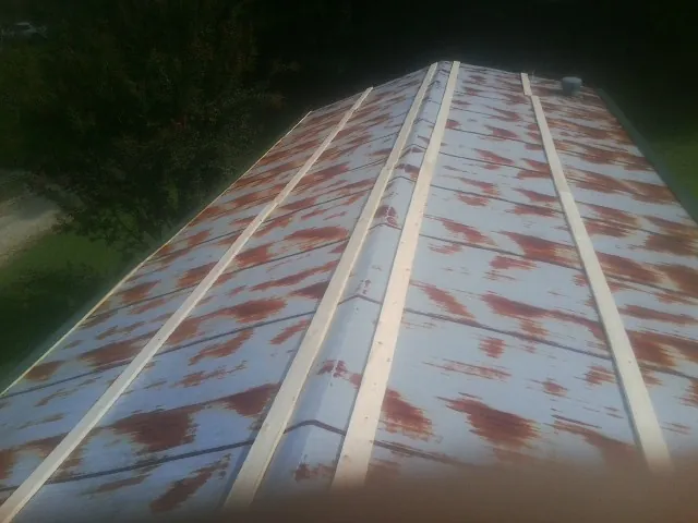 Rusted metal roof panels with new wood purlins before replacement — Storm Damage Roof Repair in Arimo by Roofing Brothers