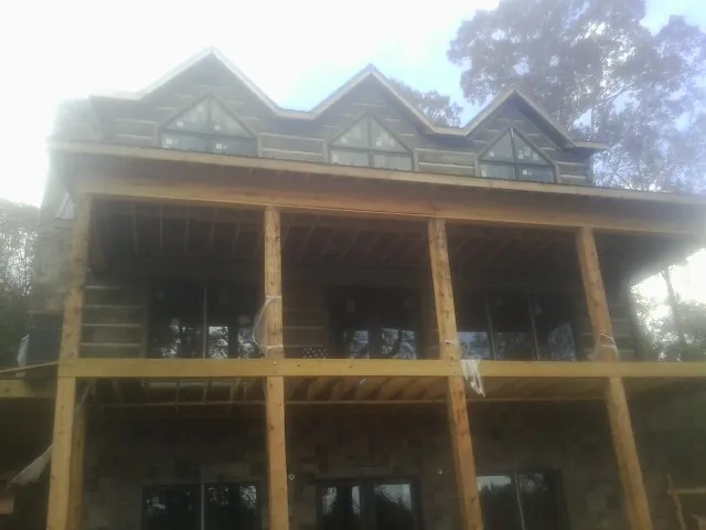 Dormers and porch framing on a large log home under construction — Roof Coating work by our crew in Arimo